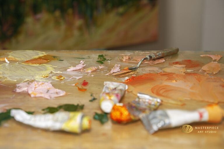 image of oil paint tubes on glass palette in artists studio